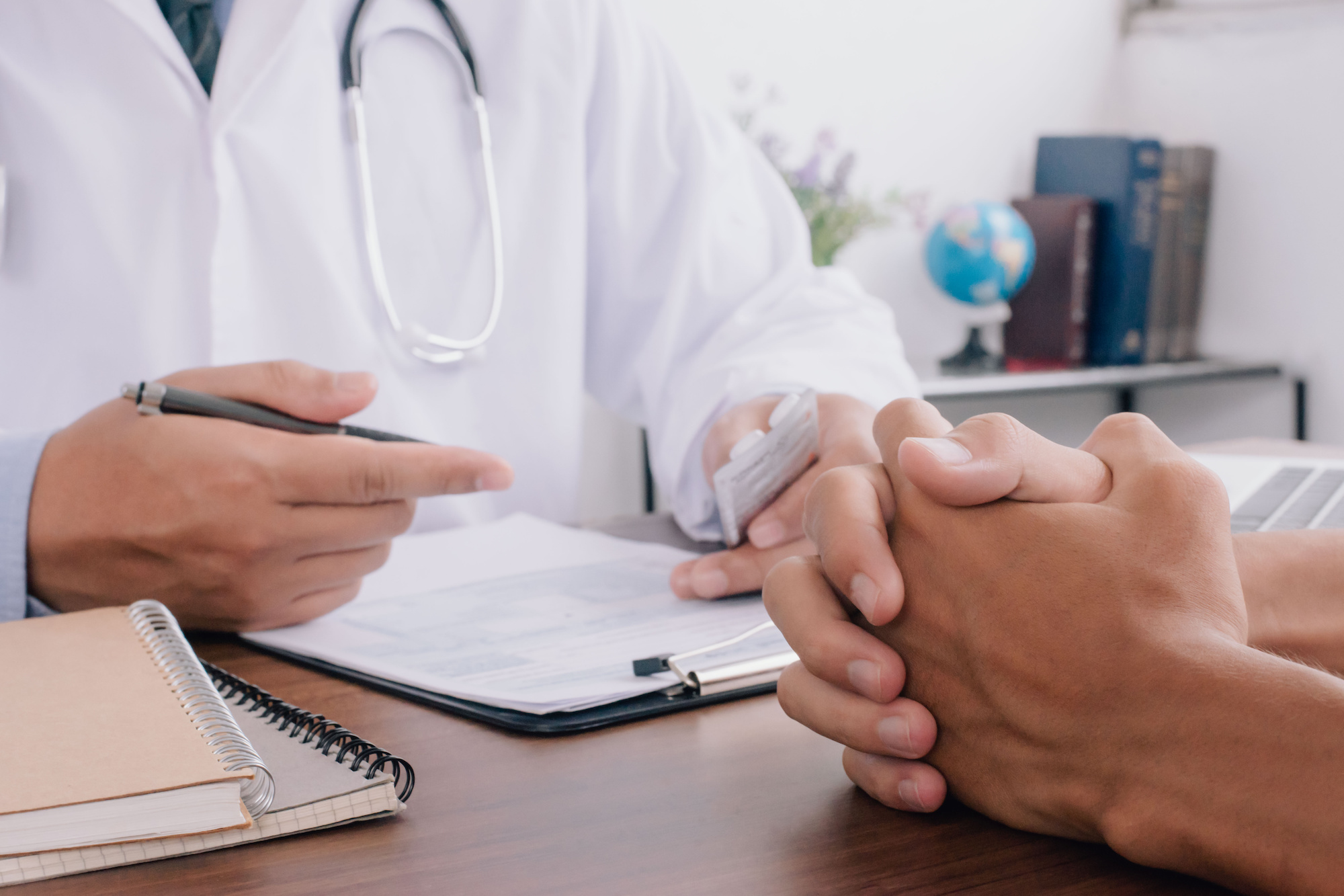 Close up of patient and doctor taking notes. healtcare and assistance concept.